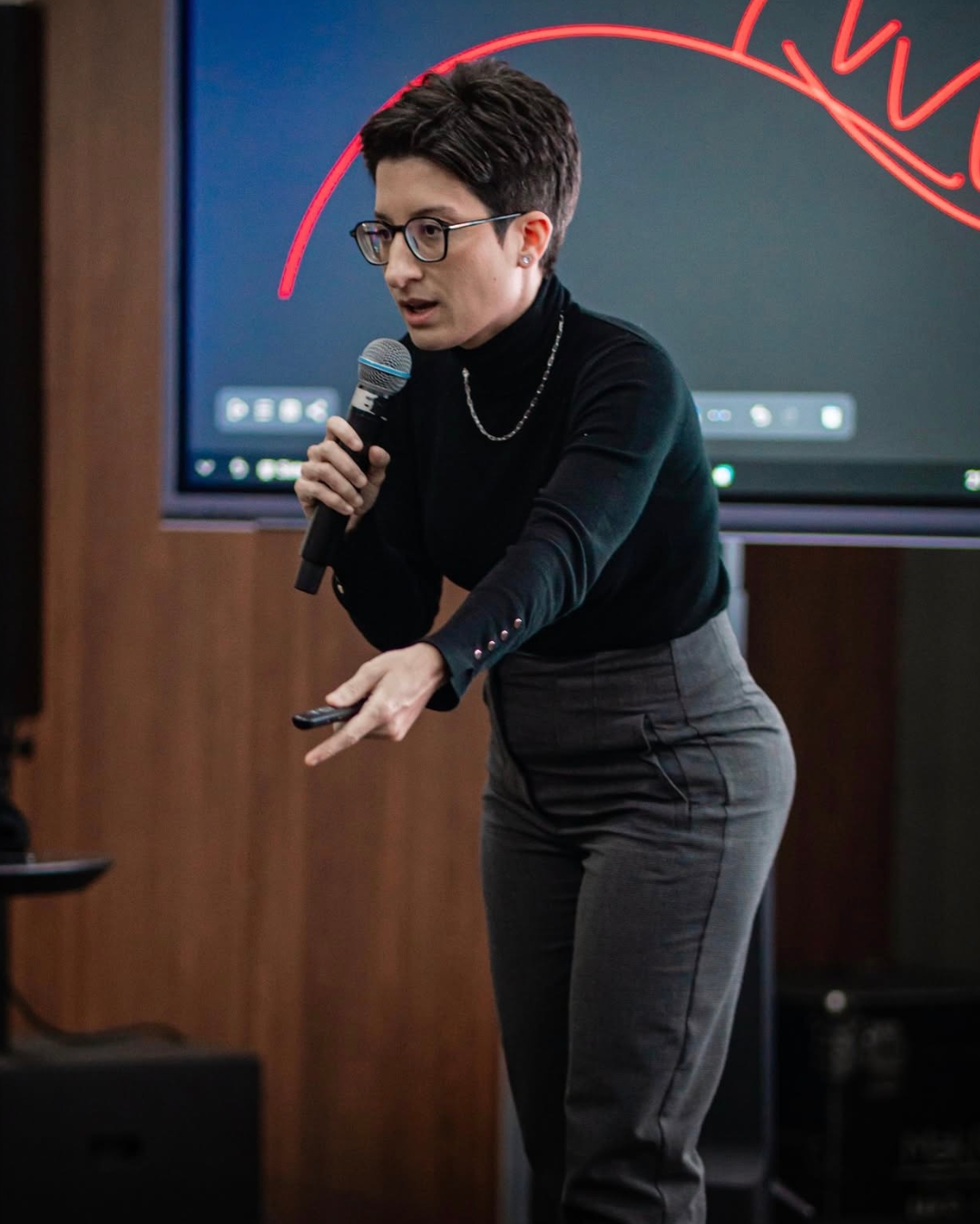 Paula Nolêto palestrando com microfone na mão